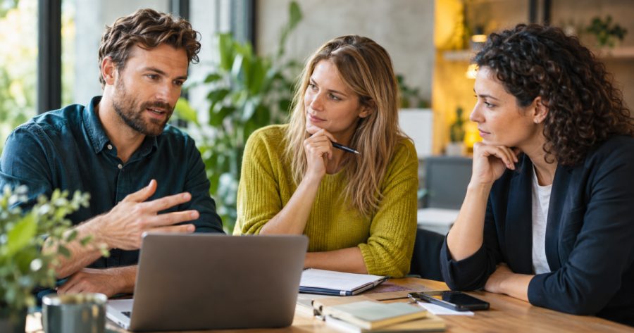 Team bespricht gemeinsam eine neue Werbestrategie anhand von Laptop und Notizen