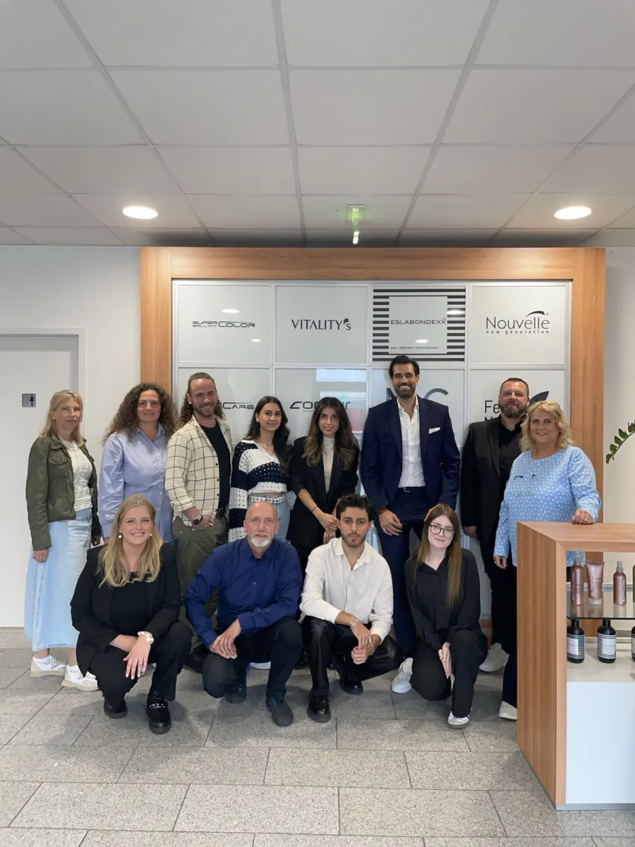 Gruppenfoto mit Alex Khan und dem Team von Hair Haus vor der Wand mit den Markenlogos